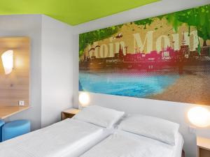 汉堡B&B Hotel Hamburg-Wandsbek的卧室配有一张床,墙上挂有绘画作品