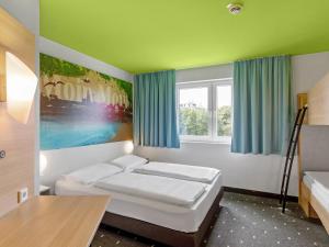 汉堡B&B Hotel Hamburg-Wandsbek的客房设有两张床和窗户。