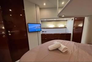 比雷埃夫斯Bliss Motor yacht Fairline Squadron 52的一间卧室配有一张床,上面有两条毛巾