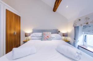 比斯顿Stunning 3-bed cottage in Beeston by 53 Degrees Property, ideal for Families & Groups, Great Location - Sleeps 6的卧室配有一张带两个枕头的大白色床