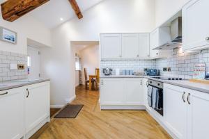 比斯顿Stunning 3-bed cottage in Beeston by 53 Degrees Property, ideal for Families & Groups, Great Location - Sleeps 6的厨房铺有木地板,配有白色橱柜。
