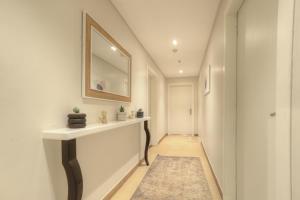 利雅德شقة راقية بحي الملقا للعوائل的走廊上设有水槽和墙上的镜子