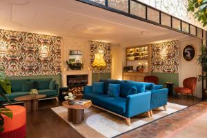 巴黎皇家马德琳酒店及水疗中心的客厅配有蓝色的沙发和桌子