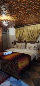 梅克内斯Riad Royal的一间卧室设有一张带木制天花板的大床