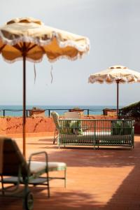 波尔图·埃尔科莱佩里卡诺酒店的海滩上的两把椅子和遮阳伞