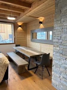莱德萨阿尔卑斯Chalet Chablis的一间设有桌子和石墙的用餐室