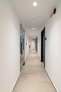 雅典Athens Theatrou Apartments的办公室大楼的走廊,有白色的墙壁和长长的走廊