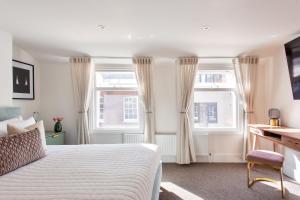 伦敦2 Bedroom Apartments in Covent Garden的卧室配有白色的床和2扇窗户。
