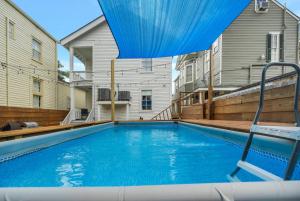 新奥尔良Magazine Manor W Pool的游泳池上方设有蓝色遮阳伞