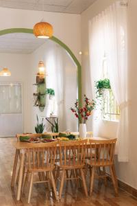 槟知Entire First Floor - Nguyên Tầng Trệt- Nhà Mơ Homestay Bến Tre的一间带木桌和椅子的用餐室