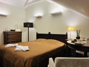 考纳斯蒙特帕斯酒店的一间卧室配有一张床、梳妆台和桌子