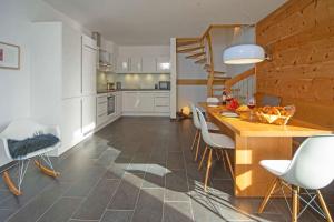 普夫龙滕Chalet am Breitenberg的厨房配有木桌和白色椅子