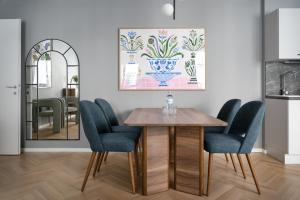 维也纳numa I Terra Apartments的一间带桌子和蓝色椅子的用餐室