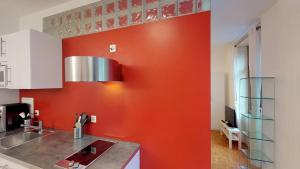 巴塞尔Unique Serviced Living @ Airport Line的厨房设有橙色墙壁和水槽