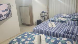 马塞约Suite Pajuçara的一间设有两张蓝色和白色床单的房间