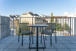 维也纳numa I Terra Apartments的阳台配有2把椅子和1张桌子