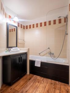 葱仁谷蒂卡尔皮埃尔假日公寓酒店的带浴缸、水槽和镜子的浴室