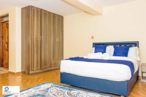 纳纽基Taliah Homestays的一间卧室配有一张带蓝白色枕头的大床