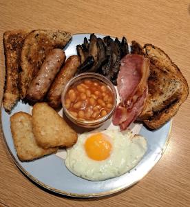 彼得伯勒Highfields Holidays bed & breakfast的包括鸡蛋培根豆和烤面包的早餐食品