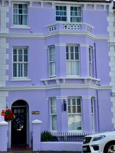 伊斯特布恩Gyves House的一座紫色的房子,前面有一辆汽车