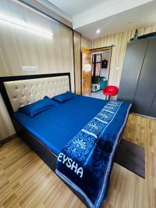 达兰萨拉Dhauladhar Homes的一间卧室配有一张带蓝色棉被的床
