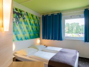 埃朗根埃尔朗根住宿加早餐酒店的配有蓝色窗帘和窗户的客房内的两张床