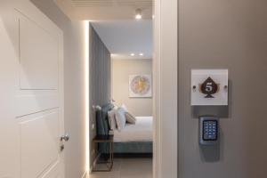 巴里Il Pumo - Apulian Rooms Bari Savoia的走廊上设有床和遥控器的房间
