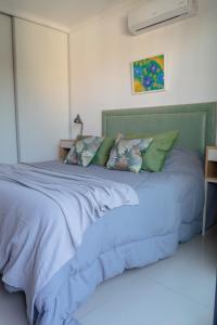 巴拉那Agustín I Apart的卧室内的一张带蓝色床单和枕头的床