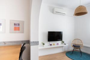 巴塞罗那Lodging Lepant 3 bedroom apartment 300 meters de Sagrada Familia的客厅配有电视和椅子