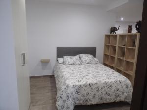 马拉加Apartamento Buen Dia airport Malaga- playa-Torremolinos的一间卧室配有一张带白色毯子和架子的床。