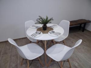 马拉加Apartamento Buen Dia airport Malaga- playa-Torremolinos的白色的桌子,白色的椅子和盆栽植物