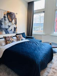 布雷达Sofia's Mansion的一间卧室设有蓝色的床和大窗户
