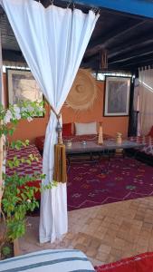 马拉喀什里亚德雨果摩洛哥传统庭院住宅旅馆的配有床和窗帘的房间