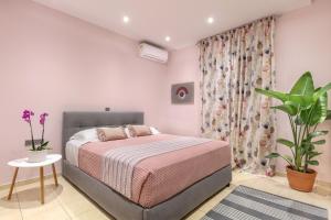 罗希姆诺Elysian Rose Residence的一间卧室配有一张床和盆栽植物