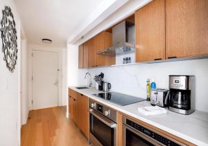 纽约Modern Studio Apartment At East Side的厨房配有木制橱柜和炉灶。