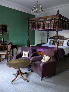 因弗鲁里Bennachie Lodge Hotel in Kemnay的一间卧室配有一张床、一张沙发和一张桌子