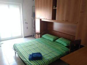 贾迪尼-纳克索斯Grazioso appartamento vicino al mare的一张带绿色床单的床,上面有蓝色的袋子