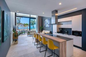阿吉内金海滩Resort Cordial Santa Águeda & Perchel Beach Club的一间带酒吧、黄色椅子和客厅的厨房