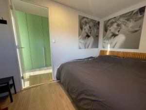斯内克Unieke loft uitzicht water的卧室配有一张床铺,墙上挂有两张女性照片
