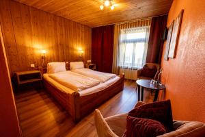 施库尔CURUNA Hotel-Garni的卧室配有床、椅子和窗户。