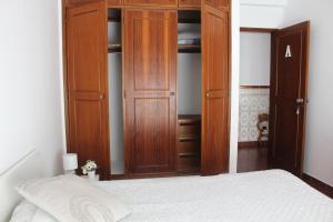 拉戈斯Guesthouse Felicidade的一间卧室配有木制衣柜和一张床