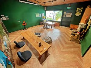 垦丁大街Kenting Original Hostel的客厅设有木桌和绿色墙壁。