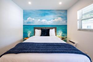 劳德代尔堡The Lauderdale Boutique Hotel的一间卧室配有一张带海洋绘画的床