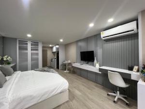 清迈Sweet room in Nimnan的一间卧室配有一张床、一张书桌和一台电视。