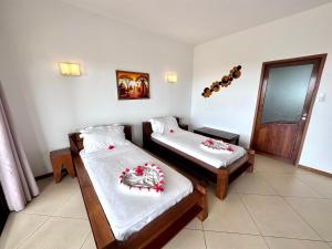 Djamandjary玛希塔萨拉酒店的一间卧室配有两张带白色床单和红色鲜花的床。