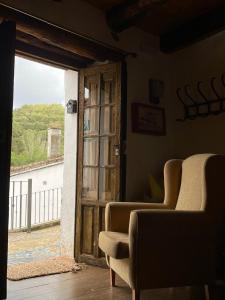 CastañueloLa Casa del Castaño的一间设有两把椅子的房间和一扇开放式的门