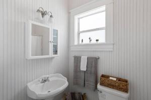 坦帕The Bays Best Bungalow的一间带水槽和卫生间的浴室以及窗户。