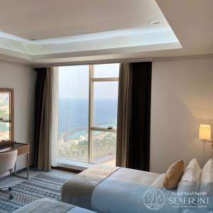 吉达Seafront Luxury Suites Jeddah Corniche的酒店客房设有一张床和一个大窗户