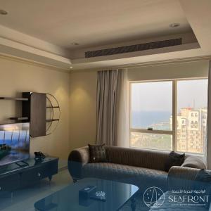 吉达Seafront Luxury Suites Jeddah Corniche的带沙发和大窗户的客厅