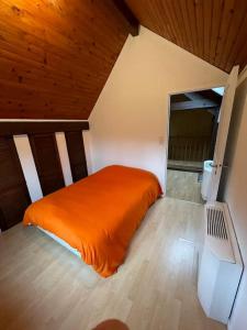 CourbouzonMaison de campagne avec piscine的阁楼卧室配有橙色床